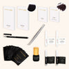 a flat lay of a small kit for volume lashes featuring two full-sized and two sample-sized boxes of lashes, some lash glue, eyepatches, and tweezers