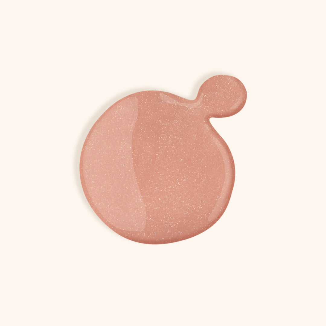 Shimmery nude gel nail polish in a white bottle