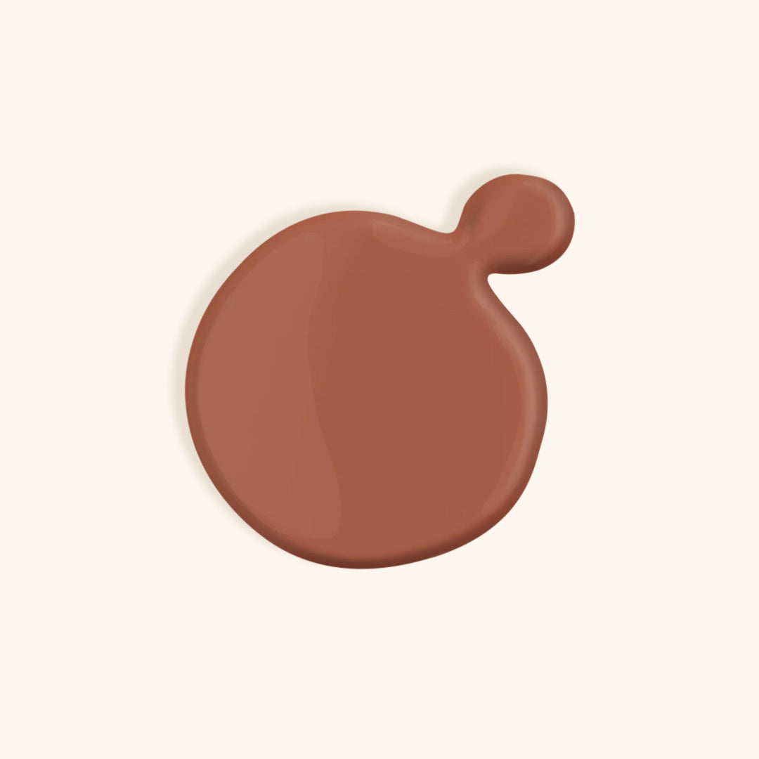 Warm nude nail polish in front of a beige background