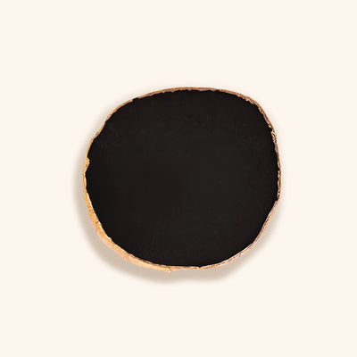 a black agate stone for lash extensions glue. It has a painted gold edge