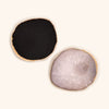 a black agate glue stone next to a white agate glue stone. each have gold edges.