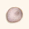 a white agate stone for lash extensions glue. It has a painted gold edge