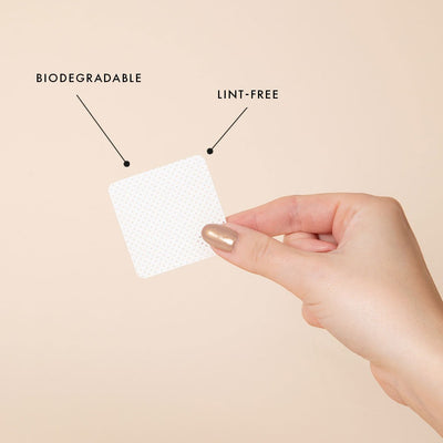 a glue nozzle wipe being held by the corner. there are two informational notes stating that the wipes are lint free, and biodegradable.