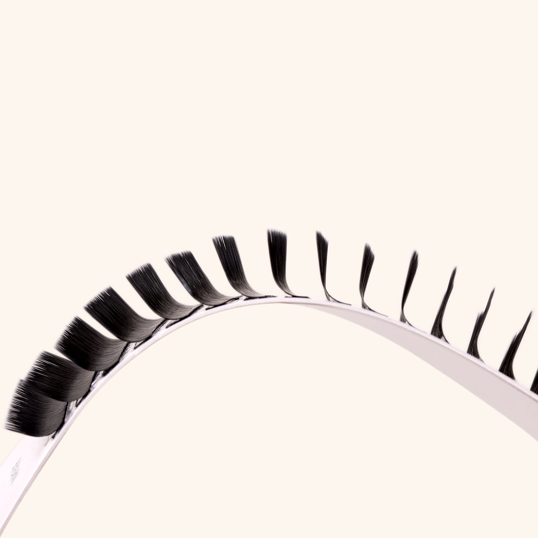 a mayfair lash card held on a curve to show the m curl lashes from the side