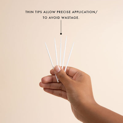 a hand holding five microfiber brushes for eyelash extensions pre-treatment with a long bendable tip