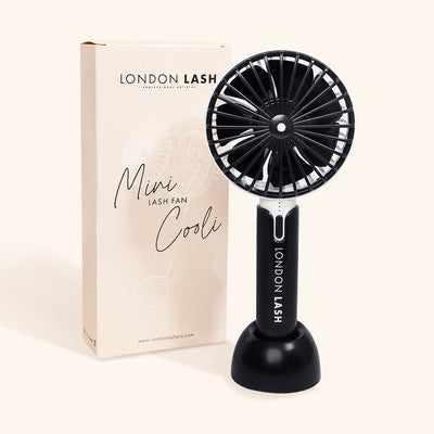 the london lash mini cooli lash fan in its base stand in front of its box