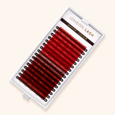 a tray of red eyelash extensions. half of the strips are bright red lashes and the other half are brick-red